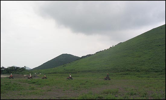 오름 중탁을 가로지르는 오토바이 동호인들이 환호성을 지릅니다. 